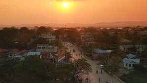 Un pueblo al atardecer con edificios, calles y vehículos.