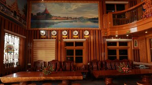 Un interior de madera tradicional con una gran mesa de comedor, múltiples sillas y un cuadro decorativo en la pared.