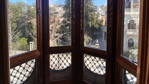 A corner room with a view of a cityscape through large windows. - ECO Hostel (Granada)