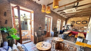 A cozy café with a rustic interior, featuring exposed brick walls, wooden furniture, and a mix of seating areas. - ECO Hostel (Granada)
