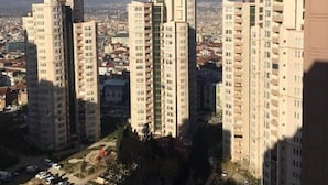 Een hoog complex van woongebouwen met meerdere appartementencomplexen, een parkeerplaats en een uitzicht op de omliggende stad.