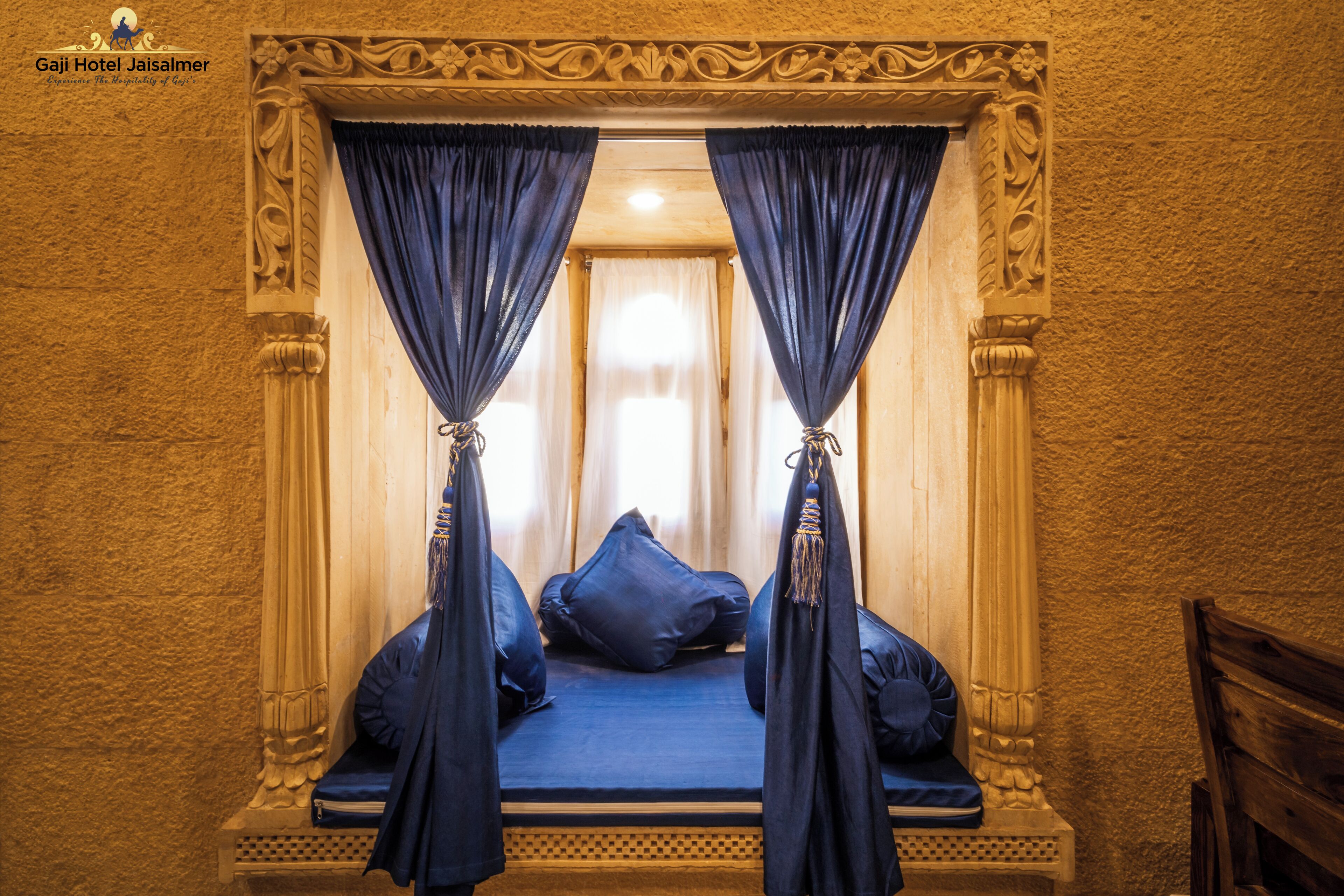 A room with a bed, blue curtains, and a decorative ceiling.