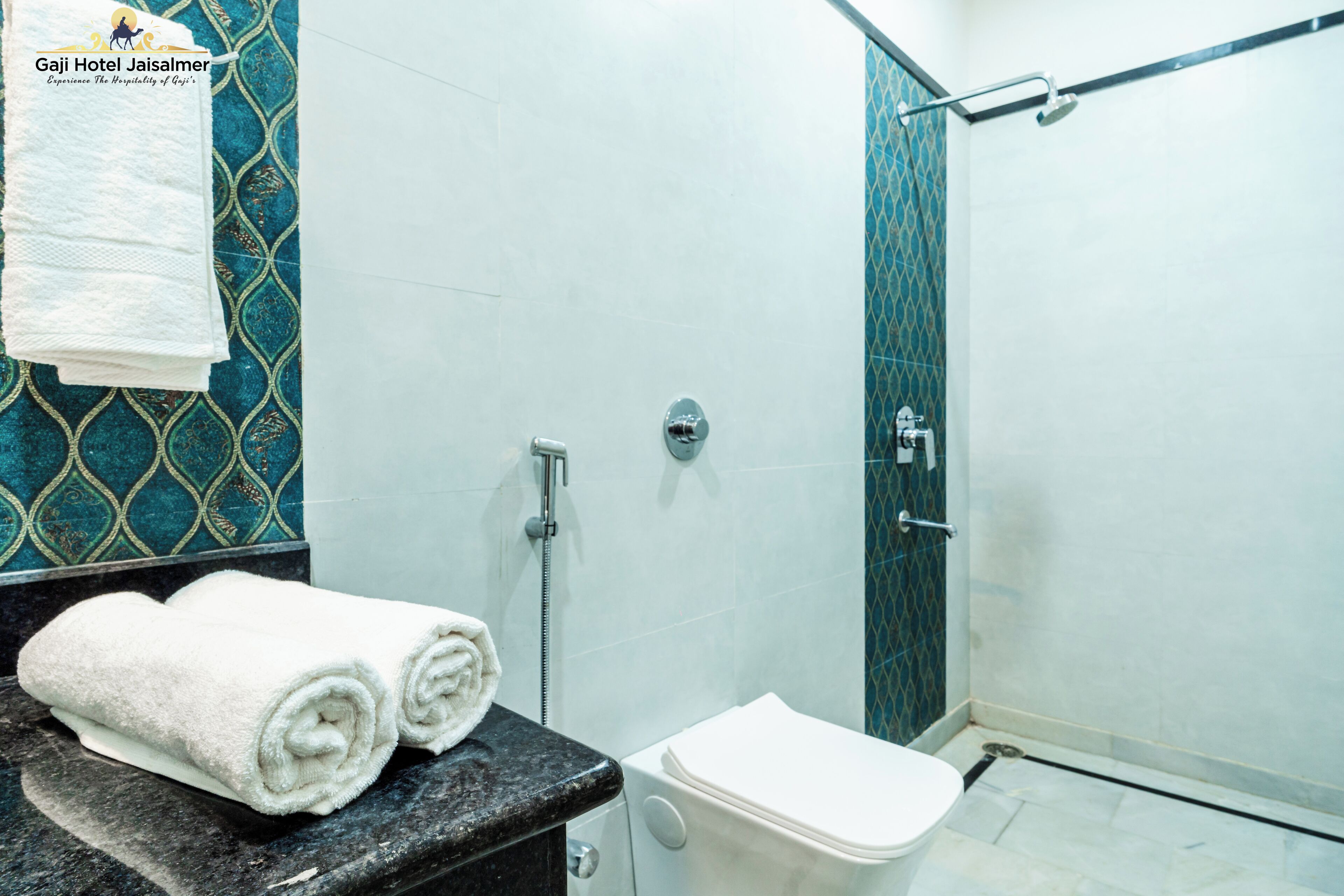 A bathroom with a shower, toilet, and a towel rack with towels.