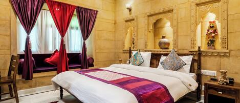 Une chambre d’hôtel spacieuse, dotée d’un grand lit, de décorations murales élégantes et offrant une vue sur l’extérieur.