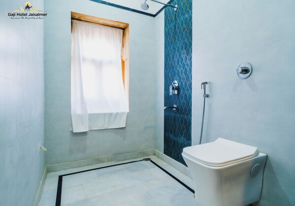A bathroom with a shower, toilet, and a window with a curtain.