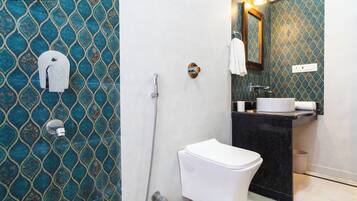 A bathroom with a white toilet, a sink, and a shower.