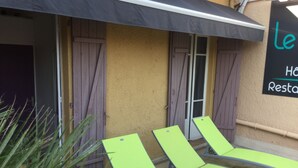 A building with a sign reading "le Hôtel Restaurant". There are two green lounge chairs outside. - Hôtel Restaurant Le 8 (Mandelieu-La-Napoule)