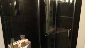 A modern bathroom with a glass-enclosed shower, a white sink, and a mirror. - Hôtel Restaurant Le 8 (Mandelieu-La-Napoule)