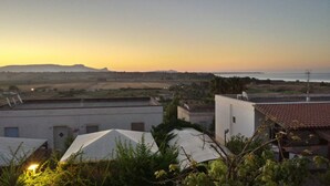 A residential area with buildings and a view of the sea at sunset. - Fenice Beach Apartment (Castelvetrano)