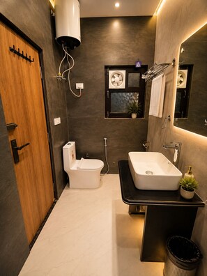 A modern bathroom with a toilet, sink, and shower.