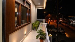 Varanda com vista para uma rua movimentada à noite.