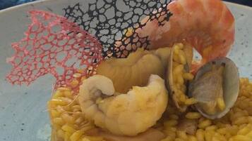 A seafood dish with rice, shrimp, clams, and mussels.
