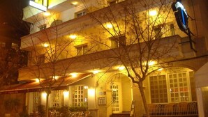 Un hôtel reconnaissable à son grand panneau en forme de « H », doté d’une terrasse et d’une entrée bien éclairée.