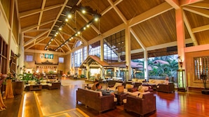 A spacious lobby with high ceilings, wooden beams, and large windows. There are multiple seating areas with sofas and chairs. - Angkor Palace Suite & Villa (Siem Reap)