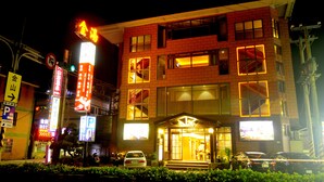A multi-story building with illuminated signage and a visible entrance. - Jinspa Resort Hotel (New Taipei City)