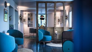 A modern living room with blue armchairs, a wooden beam structure, and a view of the outdoors. - Auberge Basque (Saint-Pee-sur-Nivelle)