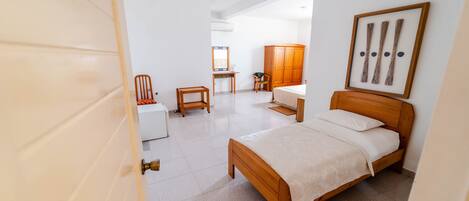 A bedroom with a wooden bed, a desk, and a chair.