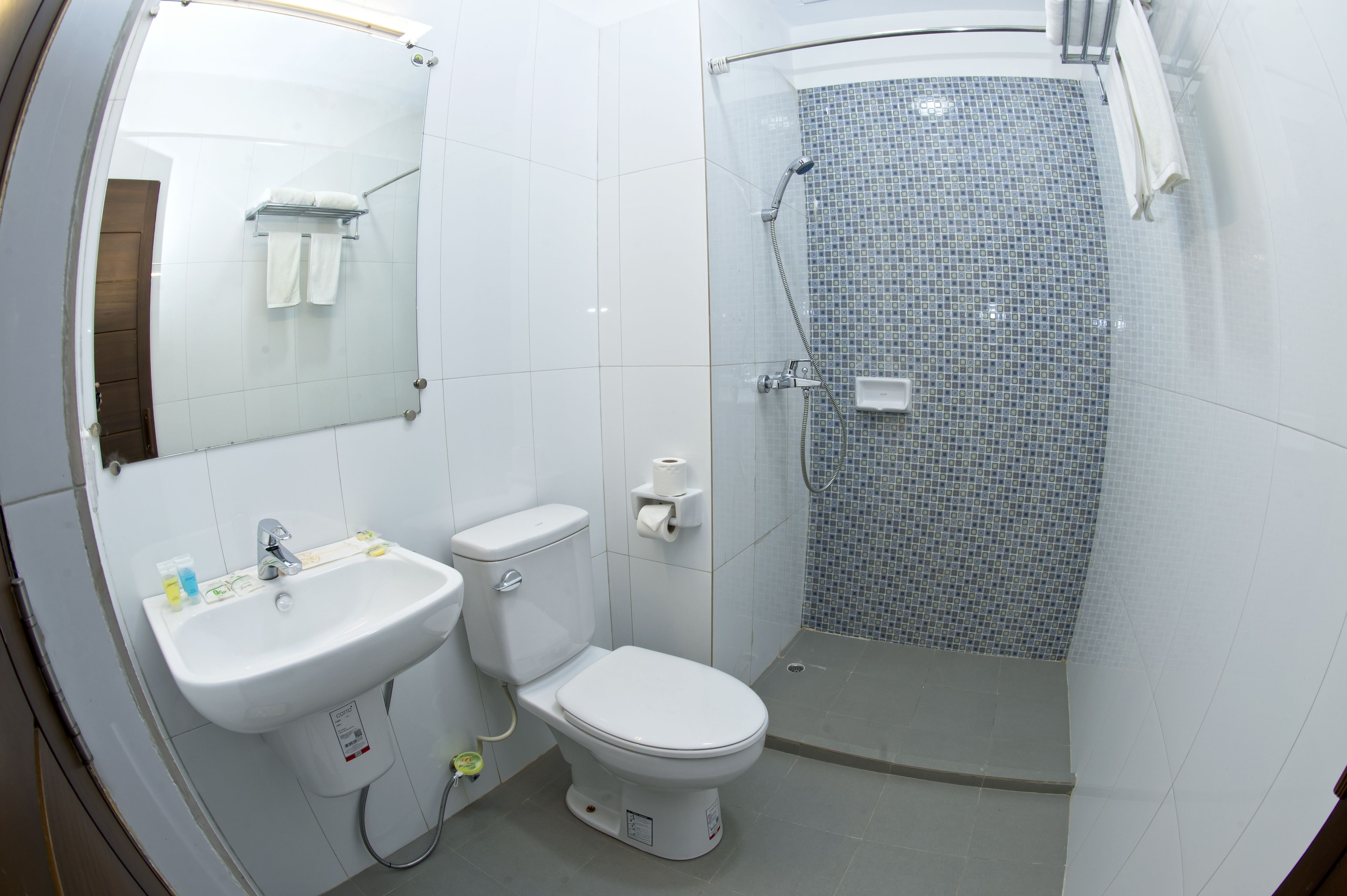 Un baño moderno con lavamanos, inodoro y ducha blancos.