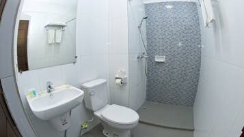 Un baño moderno con lavamanos, inodoro y ducha blancos.