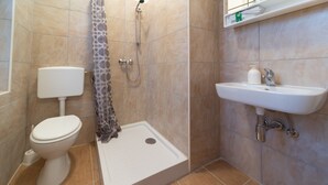 A bathroom with a toilet, shower, and sink. - Ana Hostel (Ljubljana)
