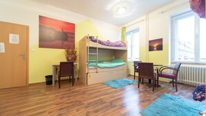 A room with a bunk bed, a desk, two chairs, a radiator, and a window with a view of a bridge. - Ana Hostel (Ljubljana)