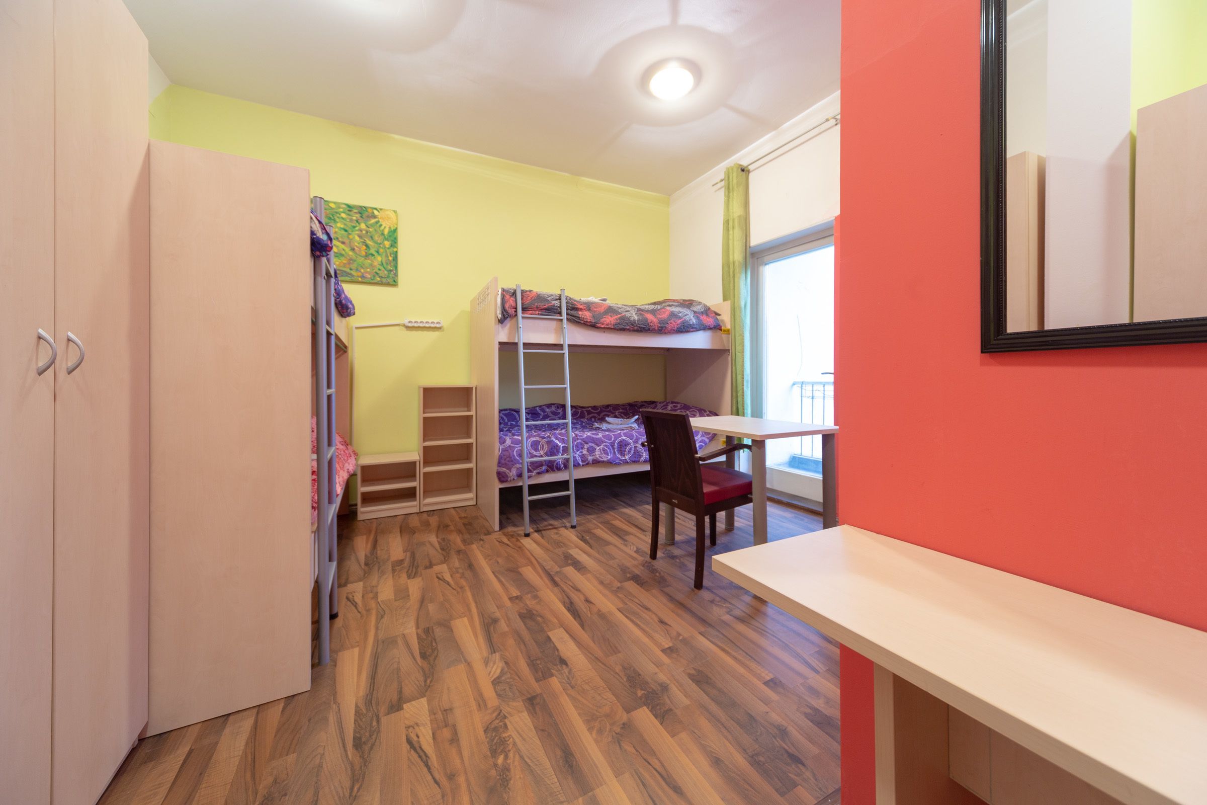 Una habitación con una cama individual, un escritorio y una silla.
