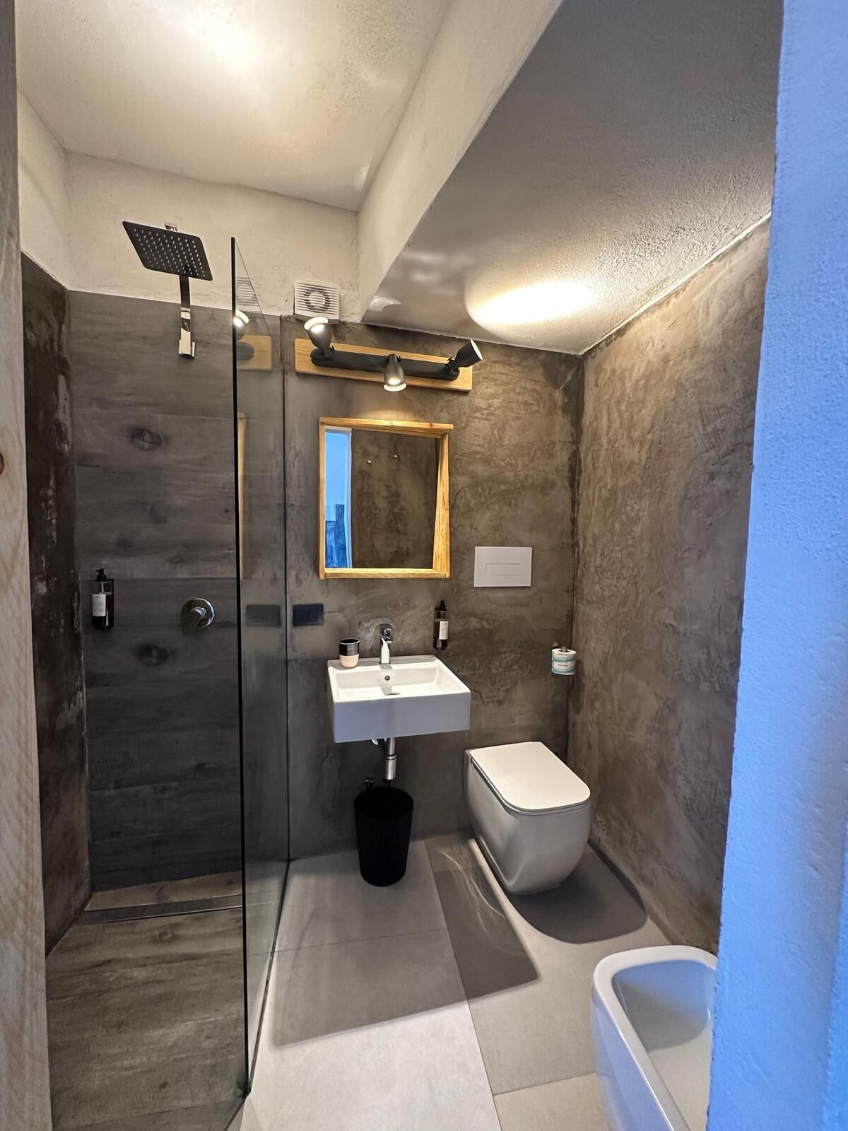 Un bagno moderno con box doccia in vetro, lavandino bianco e bidet.