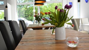 A wooden table with a white vase of purple tulips and a clear glass bowl. - Anor Hotel I Park Sleep & Fly I Frankfurt Airport (Moerfelden-Walldorf)
