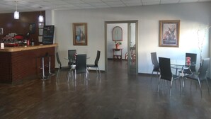 Amplia habitación con mostrador de recepción, varias sillas y cuadros en las paredes.
