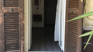 An open wooden door leading to a hallway with a tiled floor. - Ai Leoni (Verona)
