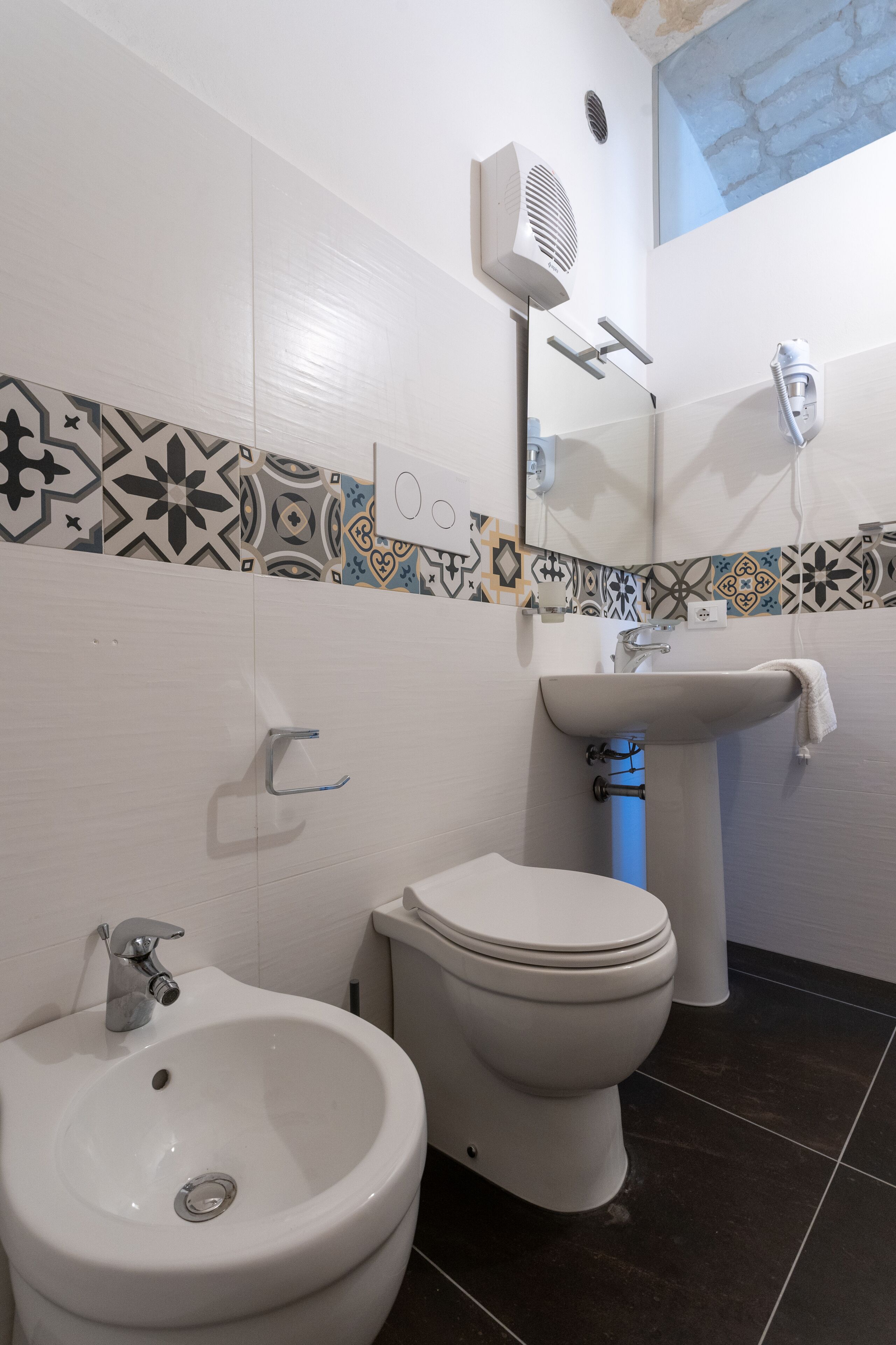 Une salle de bain équipée d’un bidet, de toilettes et d’un lavabo.