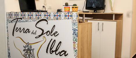 Una mesa de recepción con un letrero que dice "Terra del Sole Iblia" y una pequeña planta de cactus encima.