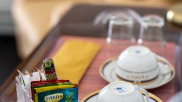 A tray with two white teacups and saucers, a yellow napkin, and a clear plastic container holding a pack of Evertea Arctic tea.
