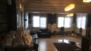 A cozy living room with a fireplace, leather sofa, and a coffee table. - Kalina Apartments (Savonlinna)