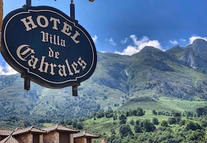 A hotel sign with the name "Hotel Villa de Cabrales" against a mountainous backdrop. - Hotel Villa de Cabrales (Cabrales)