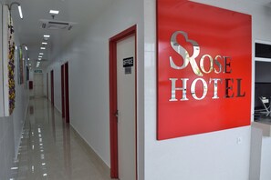 A hotel corridor with a red sign reading "Rose Hotel" and a door labeled "Office Staff Only".
