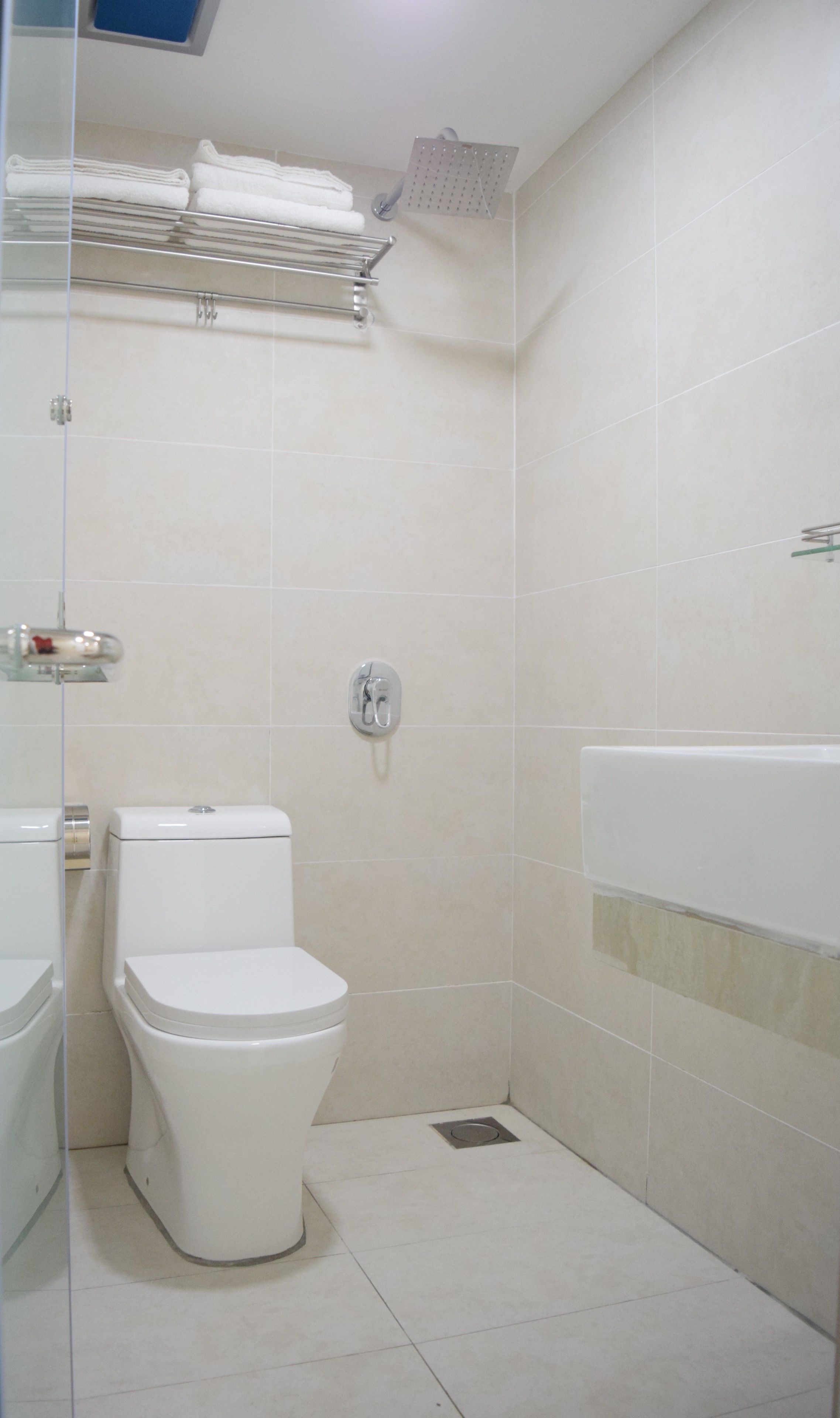 Un baño pequeño y moderno con inodoro, ducha y lavabo.