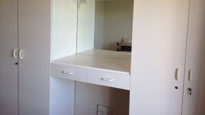 A white wardrobe with two drawers and a mirror.