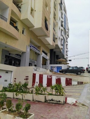 A multi-story building with commercial spaces on the ground floor, including a professional makeup salon and a car wash.