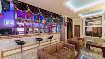 Enjoy a drink at the bar, where a selection of beverages is available. Guests can sit at the bar or on the adjacent sofa.