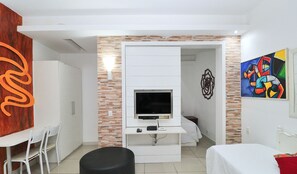 A hotel room with a TV, a bed, a desk, and chairs. - MZapartments Prado LB301 (Rio de Janeiro)