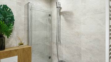 A modern bathroom with a bathtub, shower, and toilet.