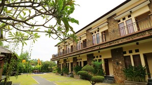 A two-story building with a central courtyard, stone pillars, and a balcony on the upper floor. - Pondok Jempiring Kuta Bali (Kuta)
