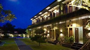 A multi-story hotel with balconies, a well-lit entrance, and a pathway leading to the building. - Pondok Jempiring Kuta Bali (Kuta)