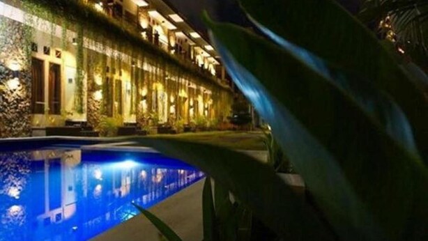 A hotel with a pool, a covered walkway, and a building with multiple windows. - Pondok Jempiring Kuta Bali (Kuta)