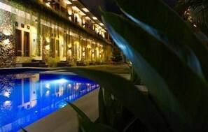 A hotel with a pool, a covered walkway, and a building with multiple windows. - Pondok Jempiring Kuta Bali (Kuta)