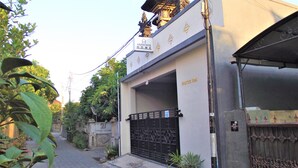 Une entrée fermée par un portail mène à un bâtiment sur lequel on peut lire l’inscription « Anantaya Home ».
