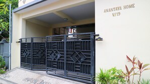 Une entrée fermée par un portail donnant accès à une propriété résidentielle appelée « Anantaya Home V/19 ».
