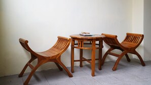 Un coin avec une table en bois et deux chaises en bois.