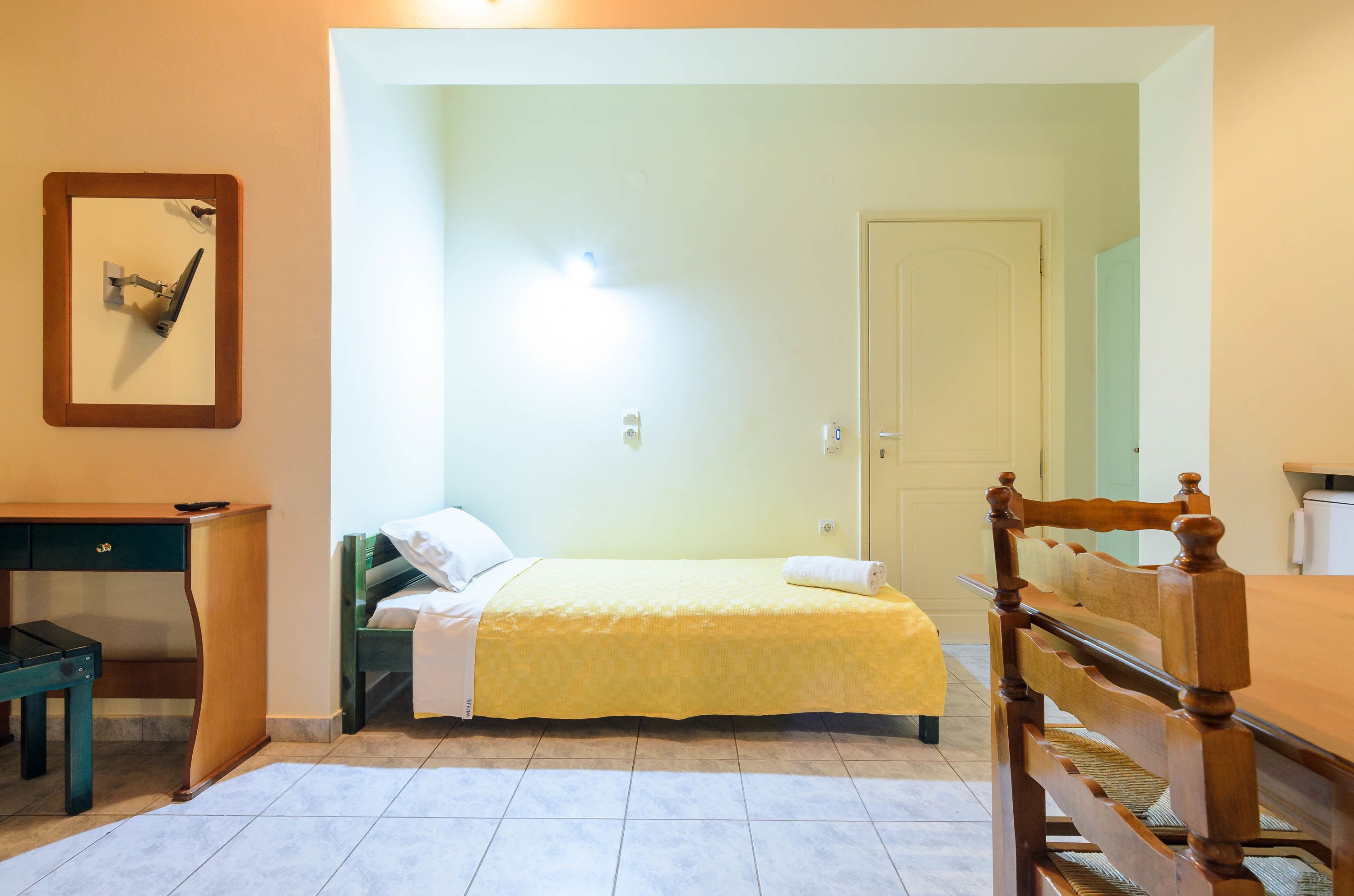 Un dormitorio con cama, escritorio y silla.